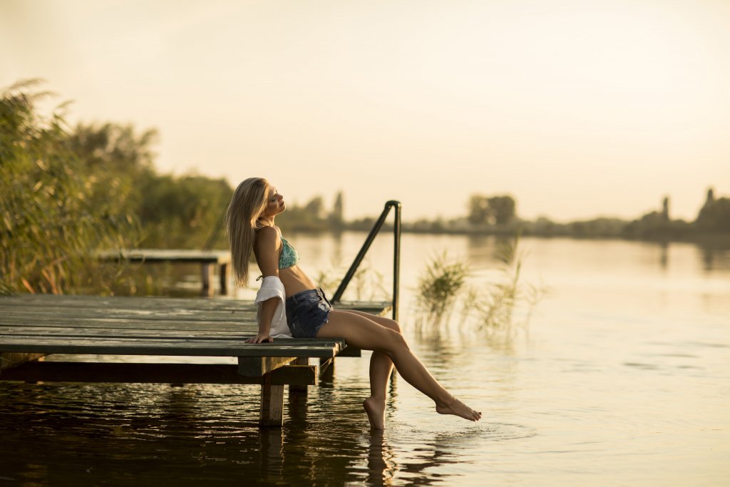 młoda kobieta relaksująca się nad jeziorem